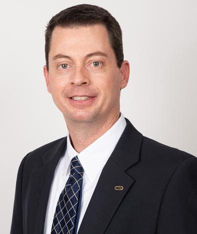 A man in suit and tie smiling for the camera.